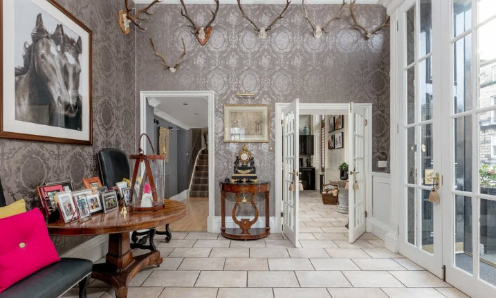 Foyer accented with deer antlers and family photos create a rustic feel